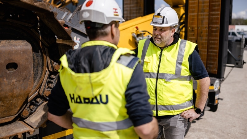 Mitarbeiter Besprechung vor Bagger